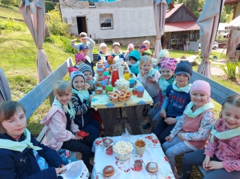 uczniowie siedzą przy stole z pączkami i smakołykami