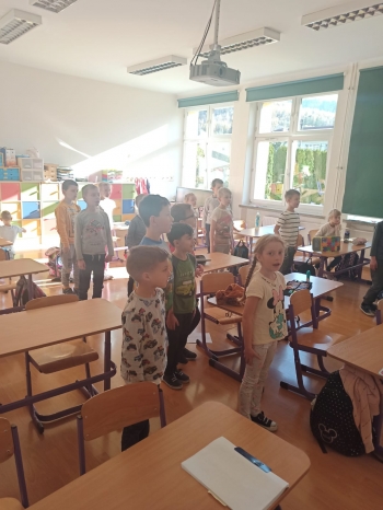 Uczniowie w klasie stojący na baczność