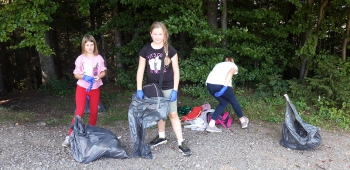uczennice zbierają śmieci koło drzew